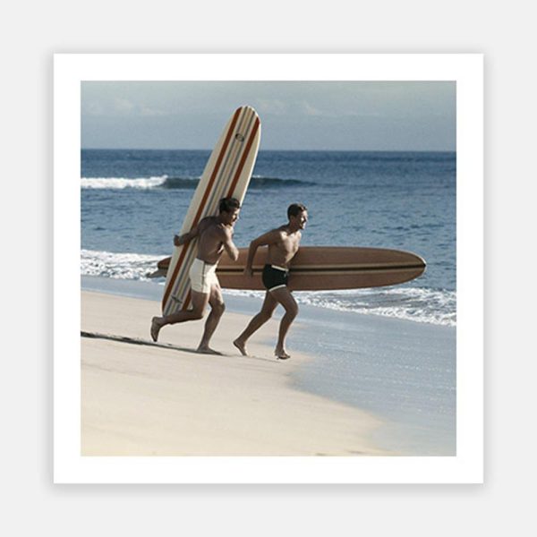 Young men running on beach with surfboard Discount